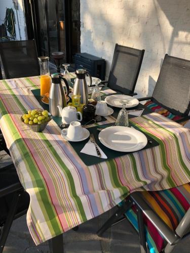 a table with a plate of food on a colorful table cloth at La Ferme de la Place in Bouvines