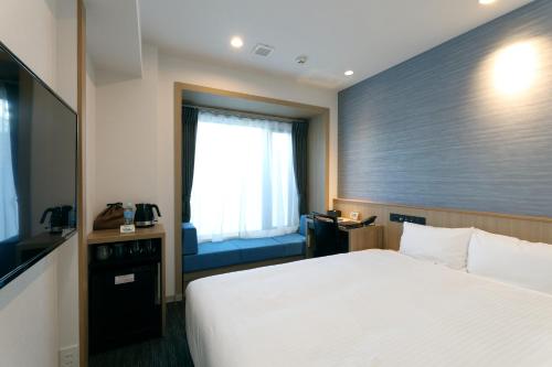 a hotel room with a bed and a window at At Inn Hotel Toyotashi Eki in Toyota