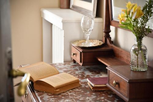a table with an open book and a wine glass at Hotel Palacio in Montevideo