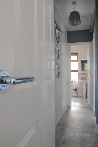 a hallway with a white door in a room at Wickham House Apartment in Fremington