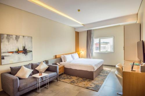 ジッダにあるEwaa Express Hotel - Al Rawdaのベッドとソファのあるホテルの部屋