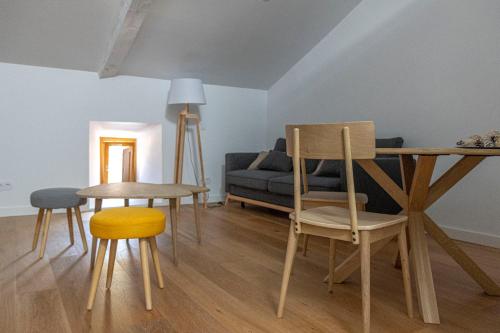 - un salon avec une table, des chaises et un canapé dans l'établissement Apartamento La Olmeda en ElMolinoDeLaSal de Sigüenza, à Sigüenza