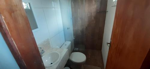 uma casa de banho com um lavatório, um WC e um espelho. em Pousada Zoe em Pirenópolis