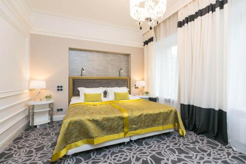 Un dormitorio con una cama grande y una lámpara de araña. en Orfei GOLD, en San Petersburgo