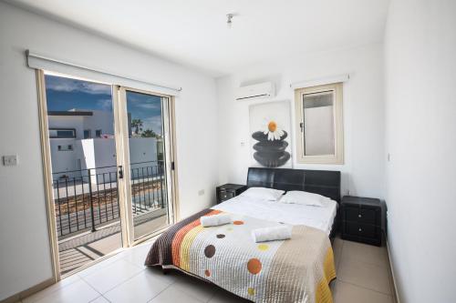 a bedroom with a bed and a balcony at Palm Villa 36 in Protaras