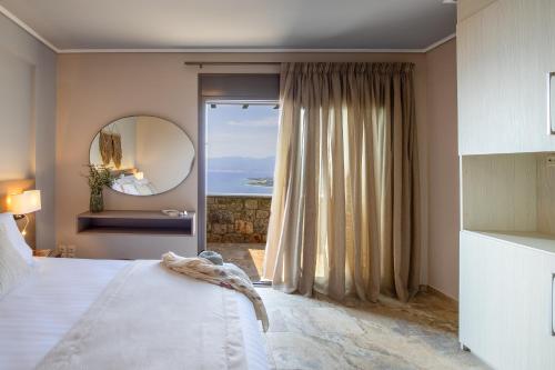 una camera da letto con un letto grande e uno specchio di Searocks Villas Exclusive Resort a Kalamáta