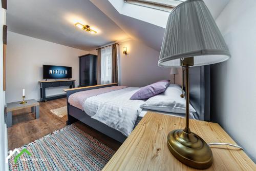 a bedroom with a bed and a lamp on a table at Green Yard Villa in Predeal