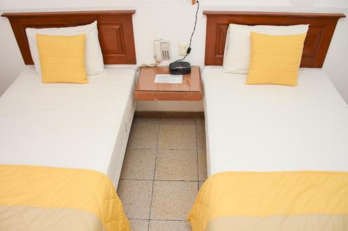 two beds sitting next to each other in a room at Hotel Camba in Oaxaca City
