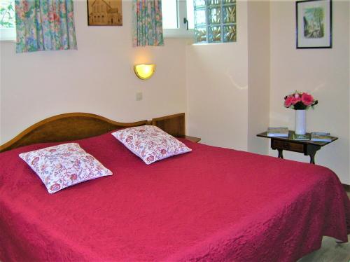 1 dormitorio con 1 cama roja y 2 almohadas en Liry's Home, en Tongeren