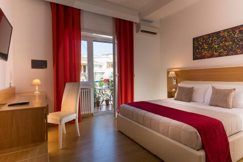 ローマにあるアウレリア 429 ファイン タウン ハウスのベッド、デスク、窓が備わるホテルルームです。
