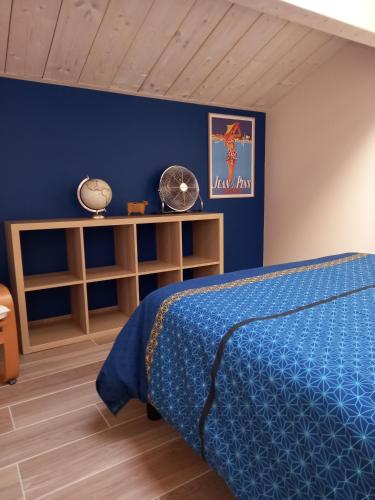une chambre avec un lit et un mur bleu dans l'établissement Gîte Mamie Cocotte, à Fuissé