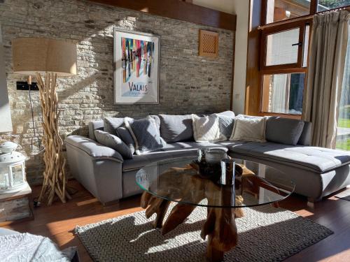 a living room with a couch and a glass table at Pirin Golf and Spa Luxury Chalet in Bansko