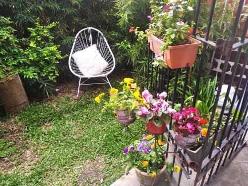 a garden with a chair and some flowers and plants at Grace’s House, Ezeiza Airport in Monte Grande
