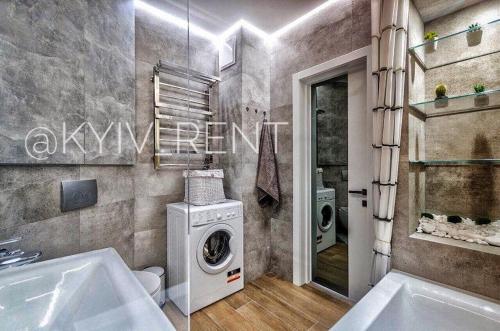 a bathroom with a washing machine and a washer at Modern VIP Smart. in Kyiv