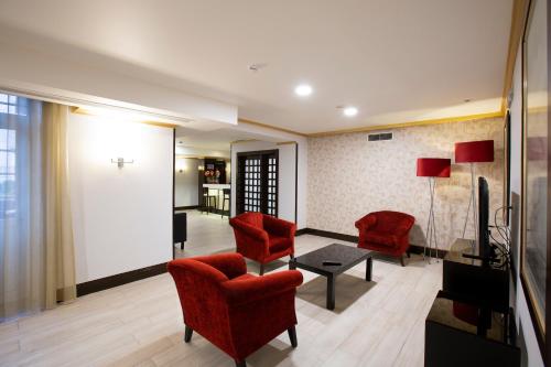 a living room with red chairs and a table at Veneza Hotel in Aveiro