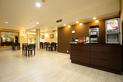a waiting room with a coffee shop and a cash register at Veneza Hotel in Aveiro