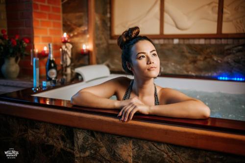 a woman sitting in a bath tub at Wellness Apartment, Spa i Sauna in Mieszkowice
