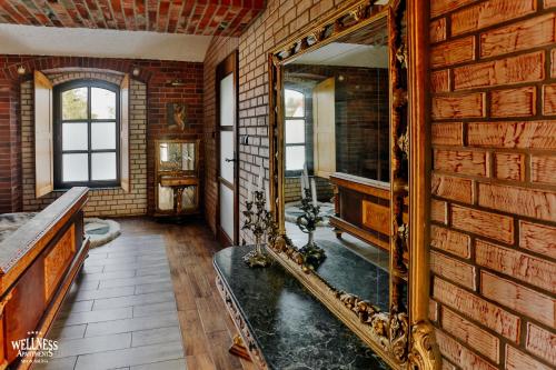a bathroom with a mirror on a brick wall at Wellness Apartment, Spa i Sauna in Mieszkowice