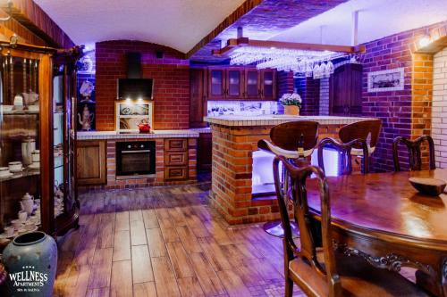 a kitchen with a wooden table and a brick wall at Wellness Apartment, Spa i Sauna in Mieszkowice