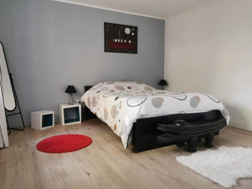 um quarto com uma cama e um tapete vermelho em " Petit Cocon 67 " cosy F2 de 65m2 proche Strasbourg em Ittlenheim