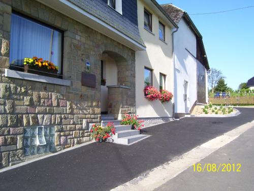 a building with flowers on the windows and stairs at Haus Neuville in Medendorf, ruhige Lage in Bullange