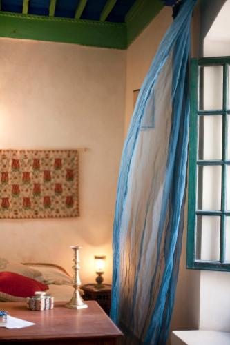 a room with a table and a painting on the wall at Daranur in Essaouira