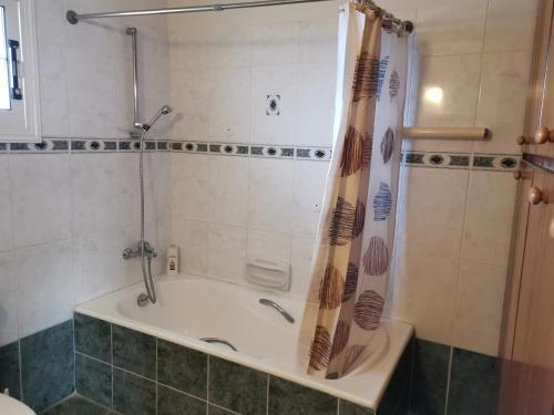 y baño con bañera y cortina de ducha. en Anastasia Apartment, en Ayia Marina
