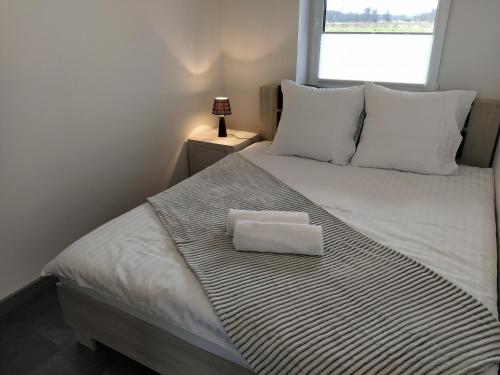 Una cama con una almohada blanca encima. en Apartament 36, en Nowy Targ
