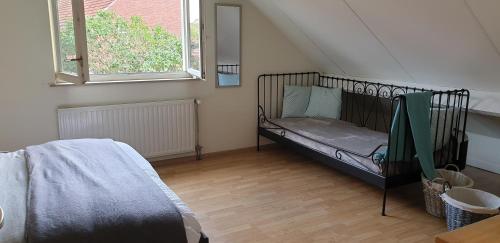 een slaapkamer met een wieg in de hoek van een kamer bij Prachtige Vakantiewoning 'la bienvenue' in Venlo, Limburg in Venlo