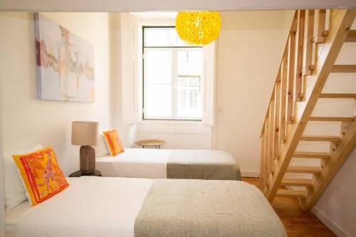 Zimmer mit 2 Betten und einer Treppe mit Fenster in der Unterkunft Cosy Baixa Apartment2 in Lissabon