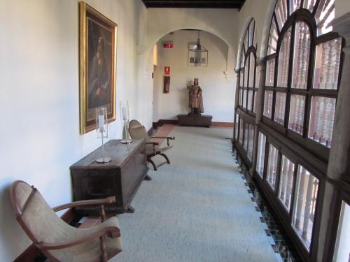 a hallway with chairs and a desk in a building at Parador de Granada in Granada