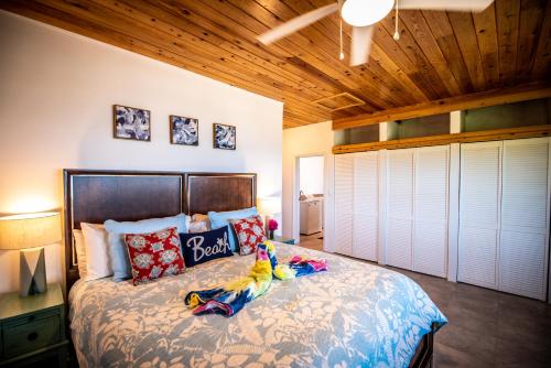 1 dormitorio con cama y techo de madera en Fantastic Penthouse at Sunset Serenade Suites, en Enighed