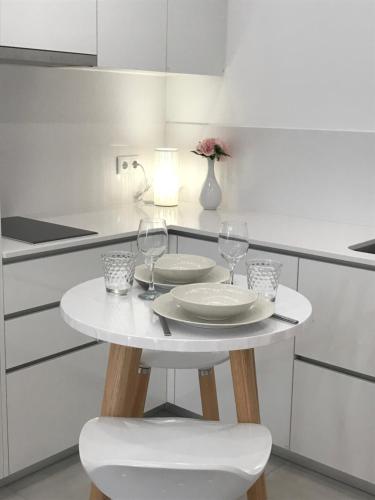 a white kitchen with a table and two wine glasses at Viana é CORAÇÃO DE OURO in Viana do Castelo