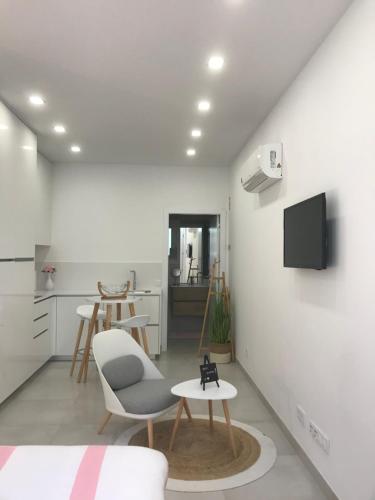 a white living room with a chair and a table at Viana é CORAÇÃO DE OURO in Viana do Castelo