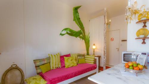 a living room with a pink couch and a table at Apartamento do Washington in Salvador