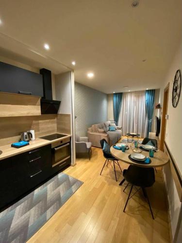 a kitchen and living room with a table and a couch at Zlatibor apartman Chill out in Zlatibor