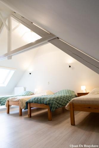 a room with two beds in a attic at Vakantiewoning Zonnehof in Sint-Margriete