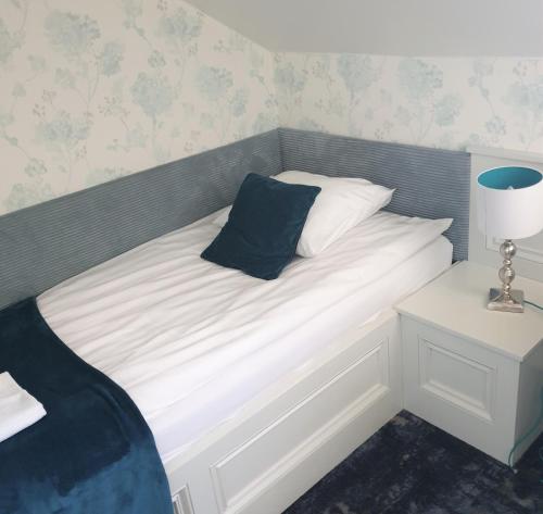 a bed with a blue pillow on top of it at Pensjonat Retro in Łomża