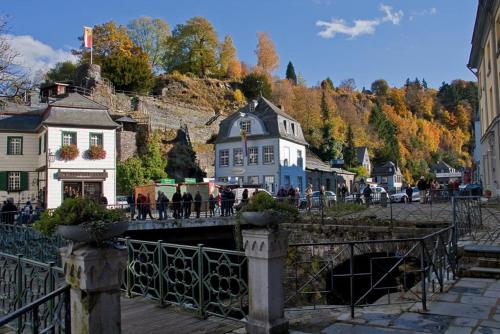 a bridge over a canal in a town with houses at Burghotel in Monschau