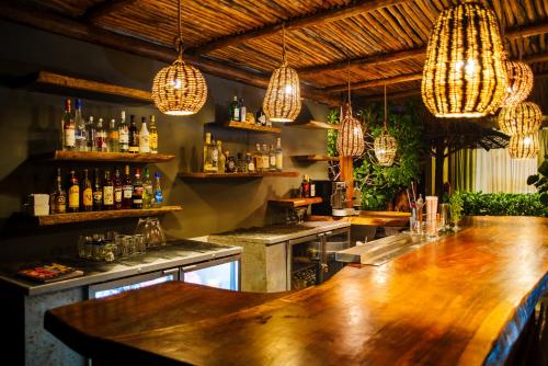 a bar with a wooden table and chandeliers at Akkuun Tulum - Adults Only in Tulum