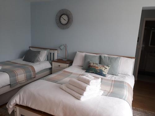 two beds in a room with towels on the bed at Coast 77 B&B in Poole