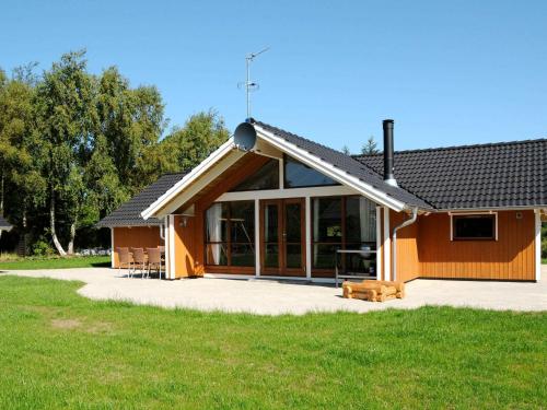 Sønder Nissumにある8 person holiday home in Ulfborgの大きな窓とパティオ付きの家