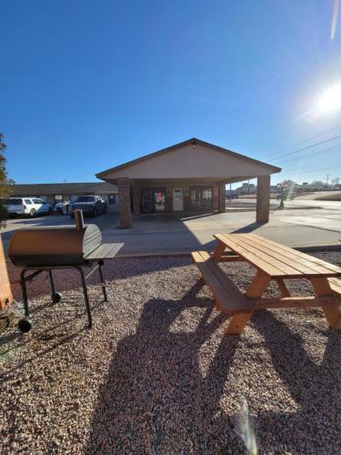 a picnic table and a grill in front of a building at Ranger Inn Alva in Alva