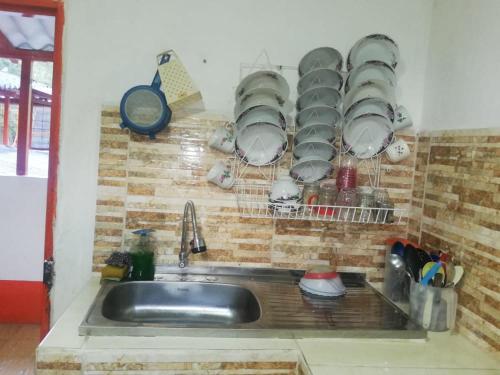 a kitchen sink with plates and dishes hanging above it at Fonda la Legia in Los Andes