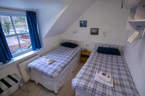 two beds in a room with a window at Corran Bunkhouse in Onich