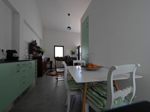 a kitchen with a table with a bowl of fruit on it at Joaninha's Beach House in Glória