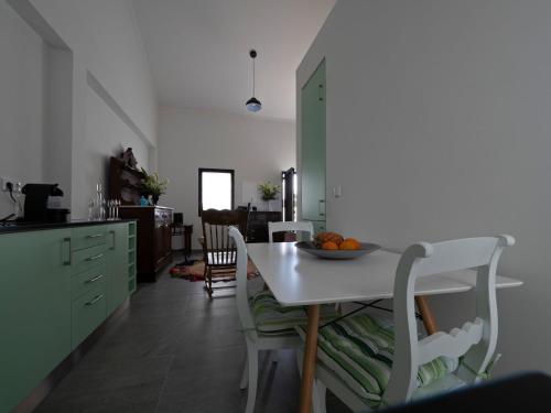 Una cocina con una mesa con un bol de fruta encima. en Joaninha's Beach House, en Glória