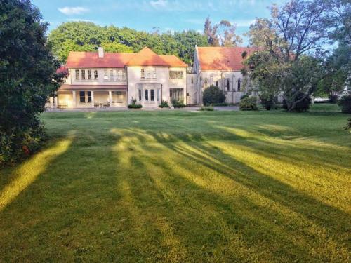 a large house with a large grass yard at Teschemakers Resort in Oamaru