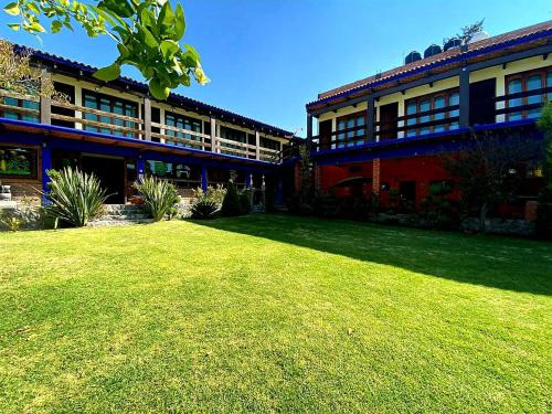 a building with a lawn in front of it at La Finca del Abuelo Teotihuacan in San Juan Teotihuacán