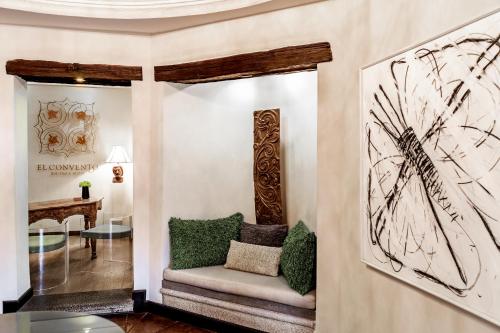 a living room with a chair and a painting on the wall at El Convento Boutique Hotel in Antigua Guatemala